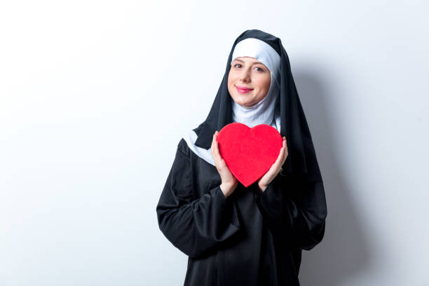 jovem freira sorridente com caixa de forma de coração - nun sign holding women - fotografias e filmes do acervo