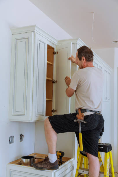 istock Installation of kitchen. Worker installs doors to kitchen cabinet. 814155642