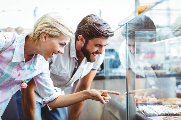 istock Cute couple on a date pointing cakes 814162790