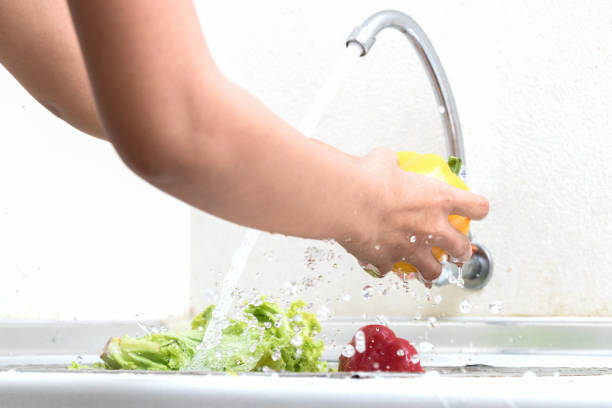 istock Woman hands are washing vegetables in kitchen 814167412