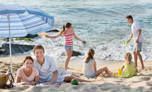 istock Parents and playing children on beach 814168030