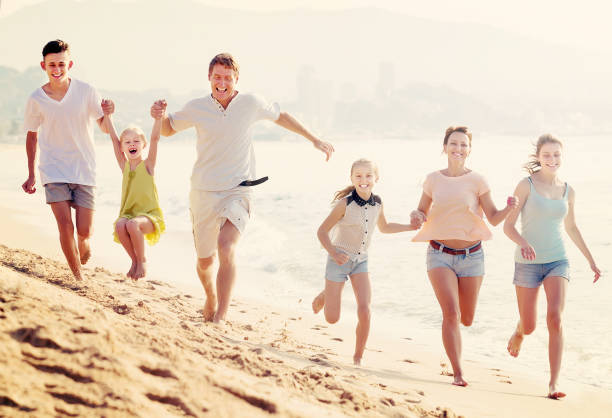 istock Family happily running together on beach 814168084