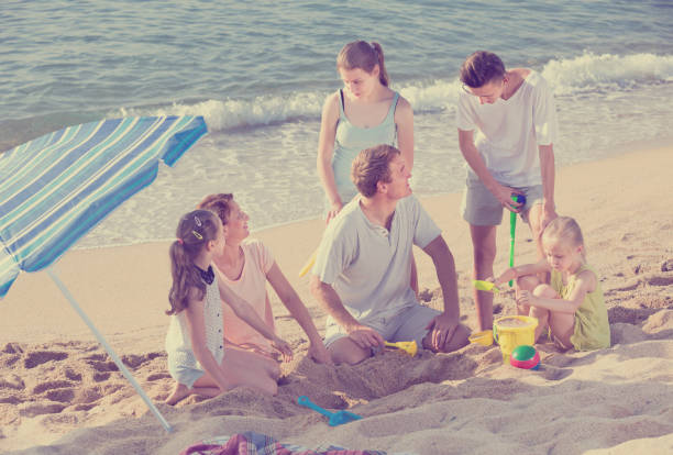 istock Large laughing family playing active games on beach 814168114