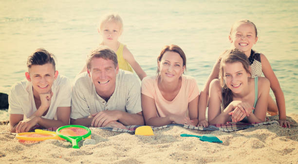 istock Parents with children lying on sand 814168202