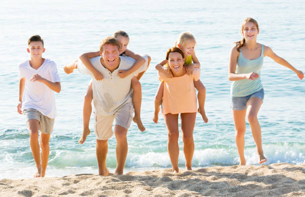 istock Parents with children walk on beach 814168212