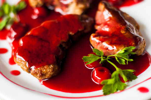 istock meat with fresh herbs and cherry sauce, ready to eat. 814170378