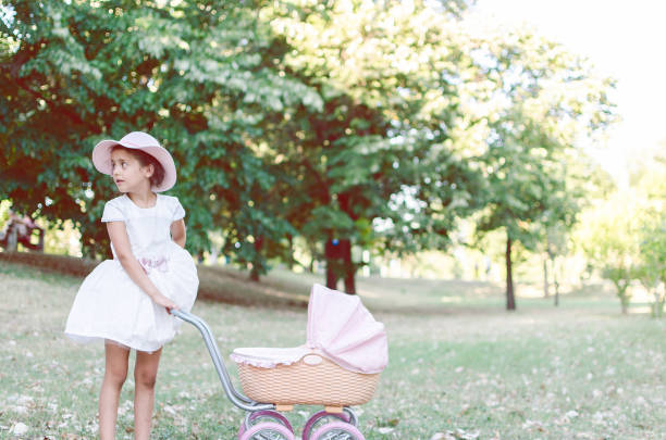 istock girl pushing strollers for doll outside 814170920