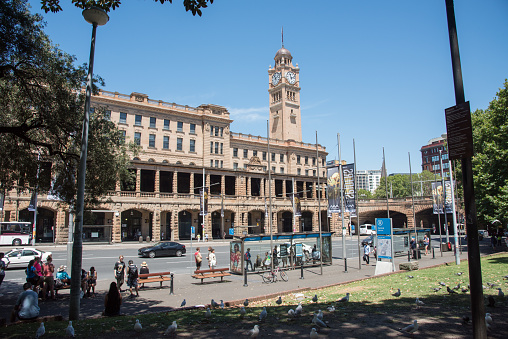 Sydney,NSW,Australia-November 18,2016: Sydney Central Railway Station with clock tower and people waiting by bus stop across from Belmore Park in Sydney, Australia.