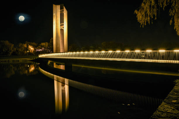 Night view showing a reflection of the Infinity Bridge, a public pedestrian and cycle footbridge across the River Tees in the borough of Stockton-on-Tees in the north east of England.