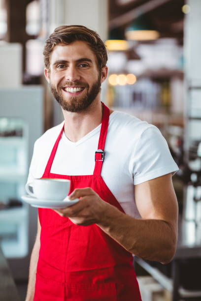 istock Handsome barista holding a cup of coffee 814183950