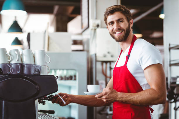 istock Handsome barista preparing a cup of coffee 814184036