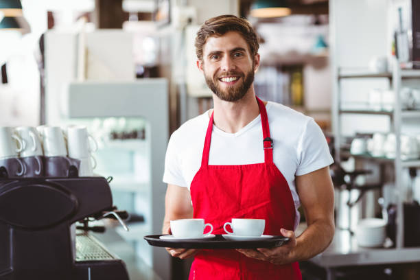 istock Handsome barista holding two cups of coffee 814184050