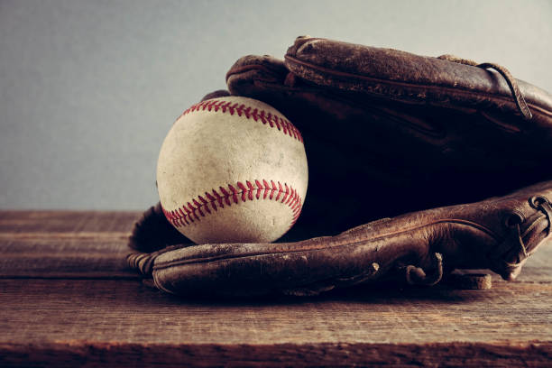 istock old Baseball and glove on wood background with filter effect retro vintage style 814191986