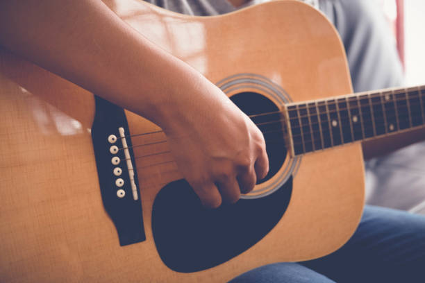 istock woman's hands playing acoustic guitar with filter effect retro vintage style 814193790
