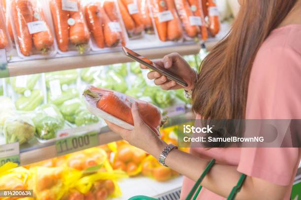 Vrouw Met Behulp Van De Mobiele Telefoon Om Te Scannen Code In Supermarkt Stockfoto en meer beelden van Barcodelezer