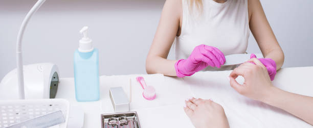 istock Manicurist does manicure with nail file 814237294