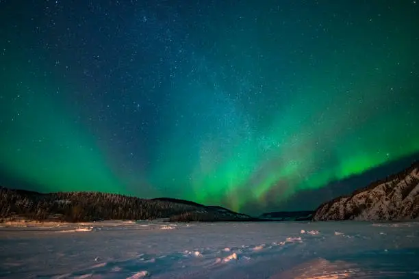 Spectacular display of Aurora borealis forming a green band over snowy winter,Yukon Territory,Canada.