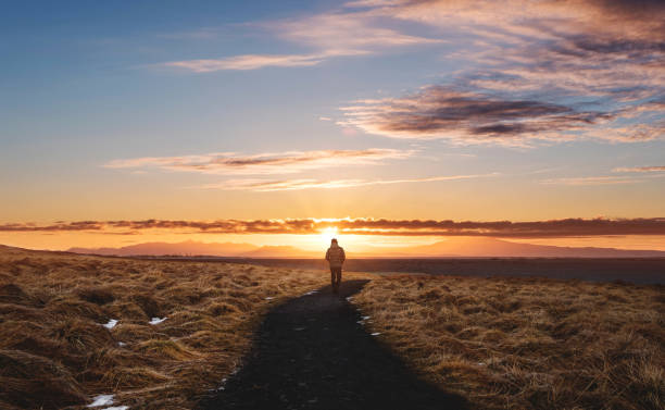 człowiek idący samotnie po chodniku, krajobrazowy islandii, w hvitserkur w sunset - walking loneliness one person journey zdjęcia i obrazy z banku zdjęć