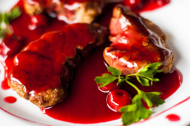 istock meat with fresh herbs and cherry sauce, ready to eat. 814263570