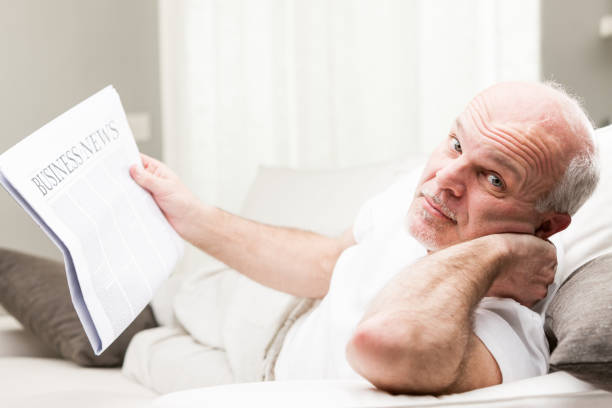 istock relaxed senior man reading business news 814271398