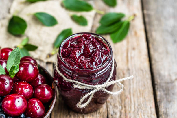 doce de ginja na jarra e cerejas frescas em uma tigela, caseira conserva sobre fundo rústico - sour cherry - fotografias e filmes do acervo