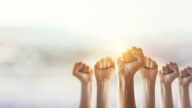 istock Peoples raised fist air fighting and sunlight effect, Competition, teamwork concept. 814278486