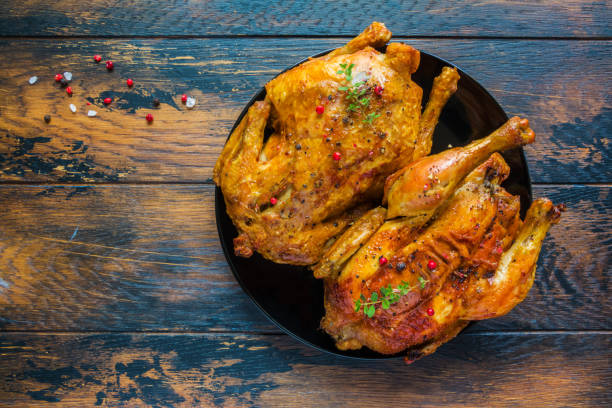 istock Crispy roasted garlic chicken with fresh thyme on a black plate on the wooden rustic table, top view. 814279852
