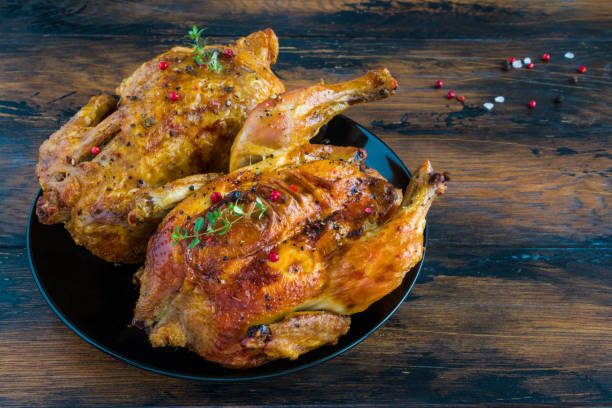 istock Crispy roasted garlic chicken with fresh thyme on a black plate on the wooden rustic table 814282330