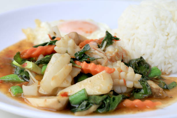 istock Asian food, Stir fried seafood with chili paste and basil leafs with rice on white plate, Spicy hot chilli Thai food. 814301012