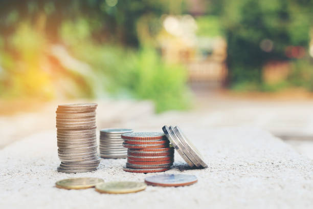 istock Stack of coins on cement floor over blurred image of green nature abstract background with vintage tone filter, Save money for growing your business, business and finance concept 814304120