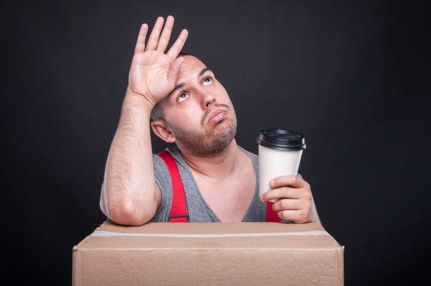 istock Tired mover guy holding takeaway coffee cup 814307516