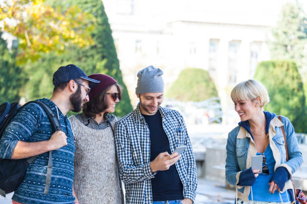 istock Friends using smart phones in park 814310392