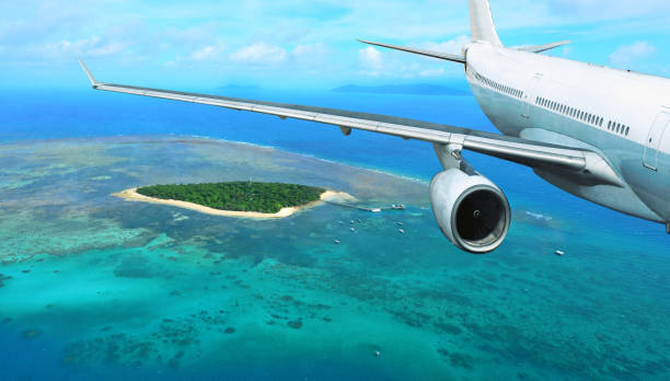 istock Passenger Plane Flies Over Tropical Island 814313418