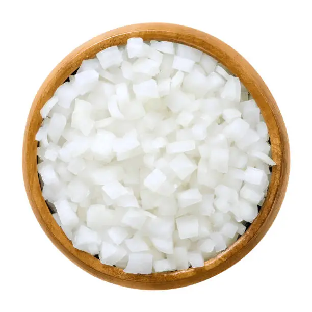 Photo of White onion cubes in wooden bowl over white