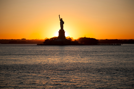 Sunset behind of The statue of Liberty