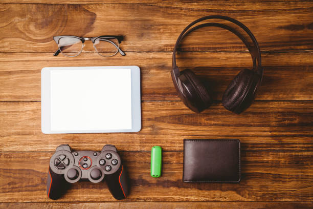 istock Tablet and glasses next to joystick music headphone and wallet 814329132