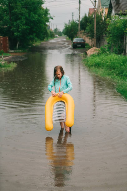 девушка, плавая в пруду после наводнения - inner tube swimming lake water стоковые фото и изображения
