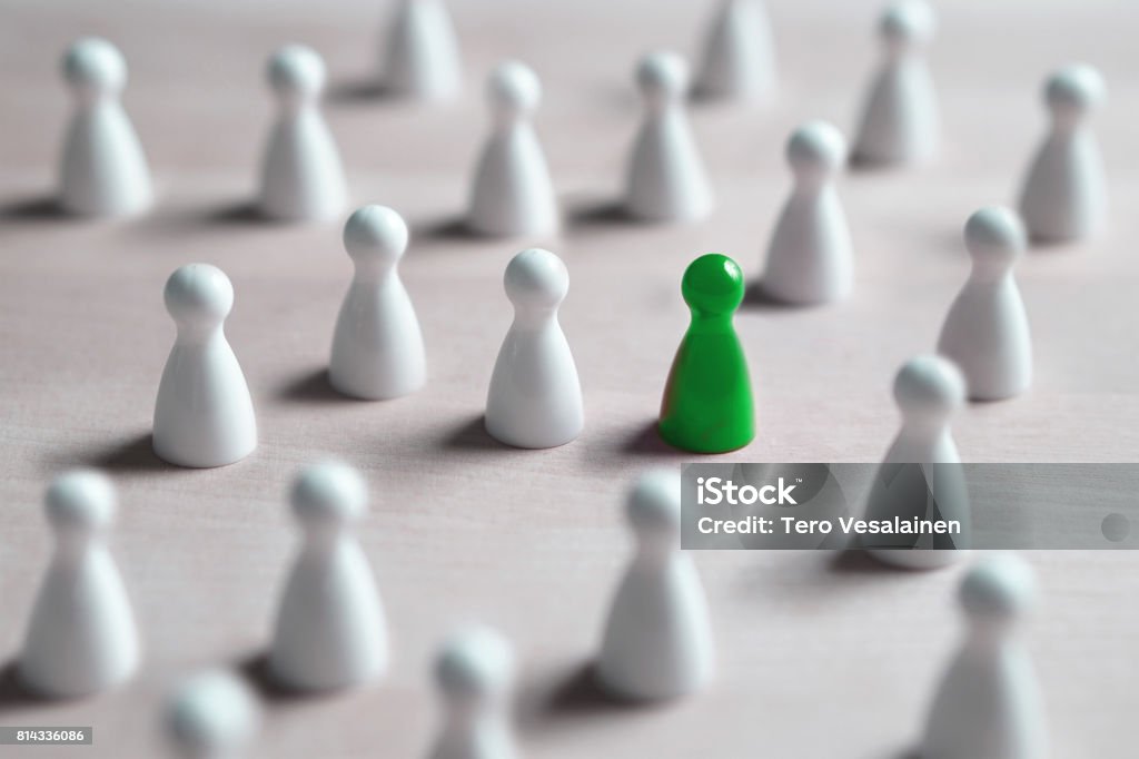 One different board game pawn. Individuality, independence, leadership and uniqueness concept. Stand out from the crowd. Think outside the box. Dare to be different. One different board game pawn Standing Out From The Crowd Stock Photo