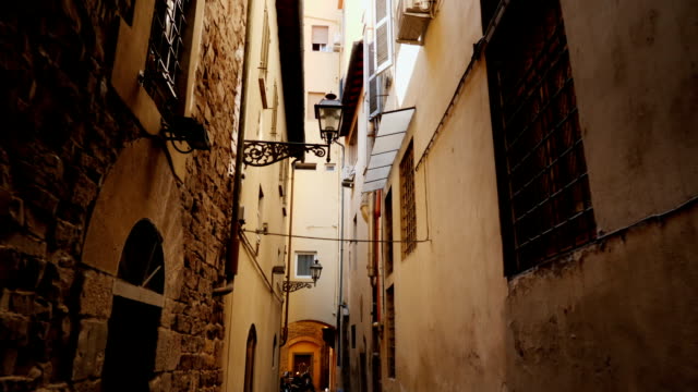 An original narrow street with old houses in the historic part of Florence. Steadicam shot