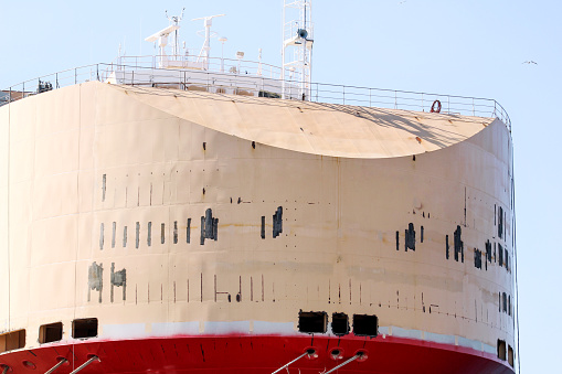 Part of a large tanker ship. Perspective view of a large rusty oil tanker. The last view of a big ship, closeup. Big boat.