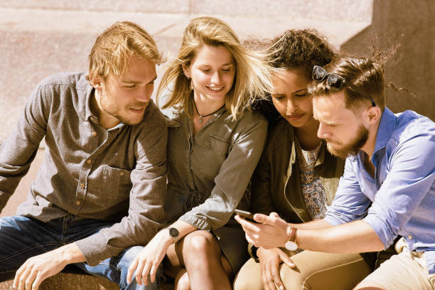 istock Group of multiracial friends having fun while looking at photos 814346594