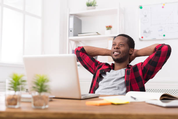 istock Young relaxed businessman with laptop in modern white office 814347070