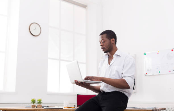 istock Concentrated black businessman in casual office, work with laptop 814347280