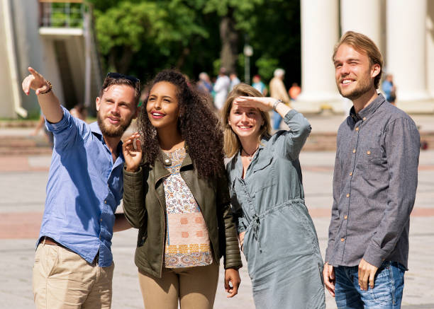 istock Young buddy pointing direction to friends in city street 814347364