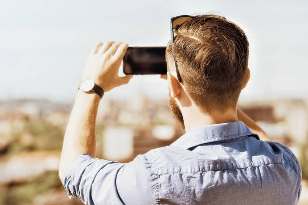 istock Young caucasian man taking photos on his mobile 814347450