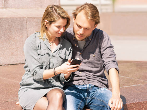 istock Young man looking at mobile phone of his girlfriend 814349134