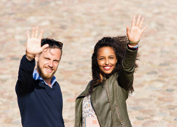 istock Young multiracial couple greeting their friends 814349696