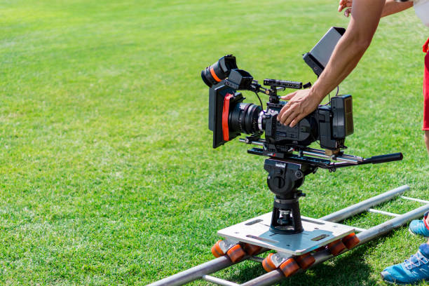 istock Close-up of working camera on slider, operator's hand and green grass. 814351050