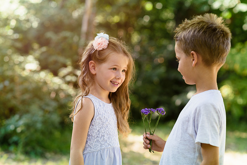 Cute little girl happy to receive a flower from a boy