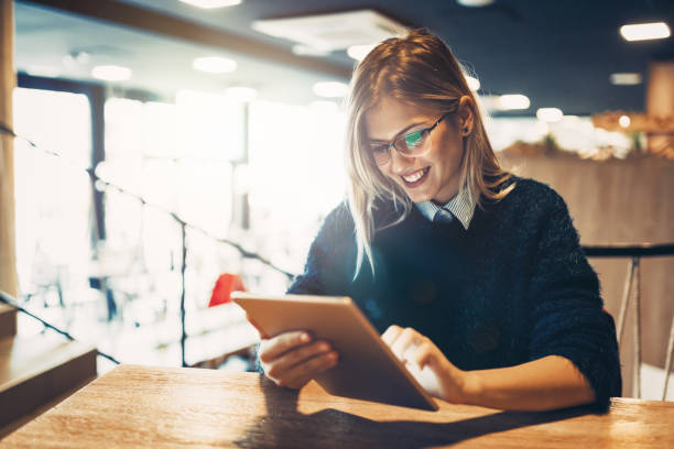 istock Happy young woman using tablet at coffee shop 814362540